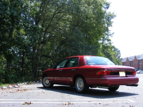 1997 Mercury Grand Marquis - Rear 3/4 view of a red 1997 Mercury Grand Marquis sedan parked in a lot.
