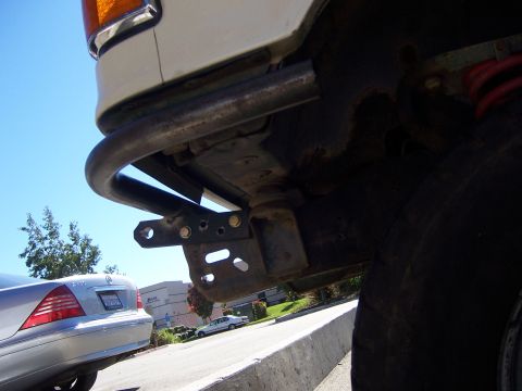 1991 Ford Bronco - Close-up of custom front bumper fabrication on a white vehicle, with other cars visible in the background.