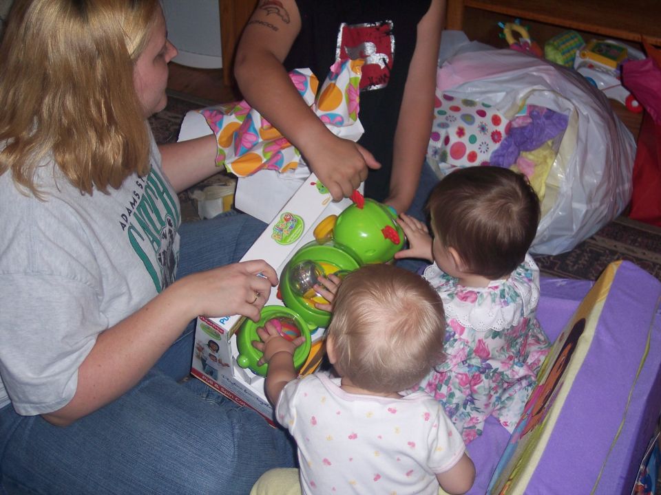 Woman and children opening a green toy