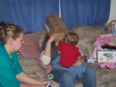 1972 Ford Ranchero - A toddler plays with a box on someone's head while another person watches on the couch.