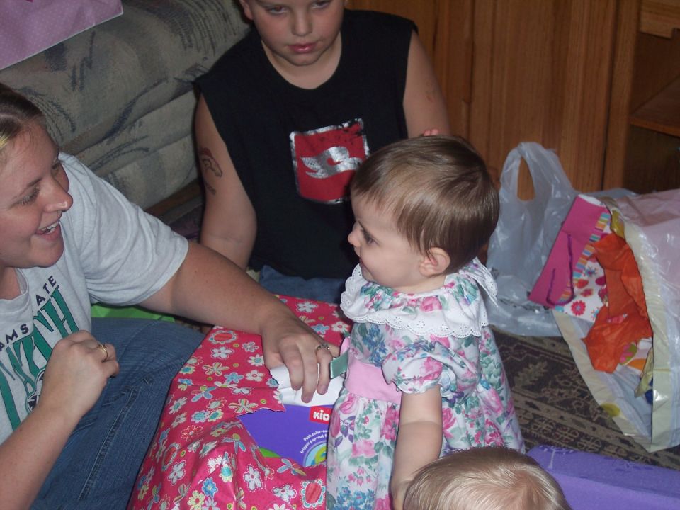 Woman and children gathered around a gift-wrapped box