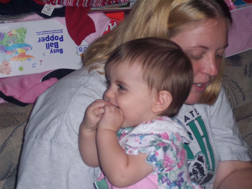 Woman holding a baby, with a toy box in the background