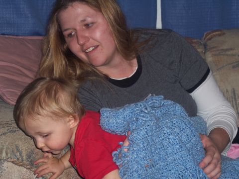 1972 Ford Ranchero - A woman and a young child are on a couch, partially covered by a blue blanket.