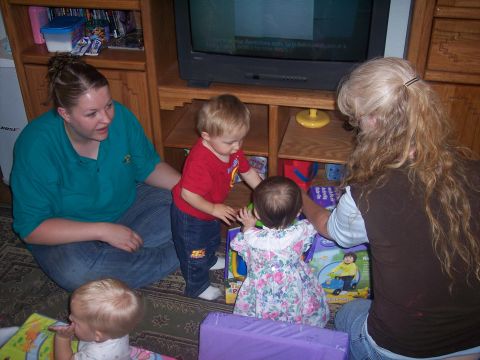 1972 Ford Ranchero - A group of people, including young children, interact with toys in a living room setting.