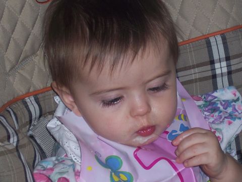 1972 Ford Ranchero - A baby is eating and has food around its mouth while wearing a bib.