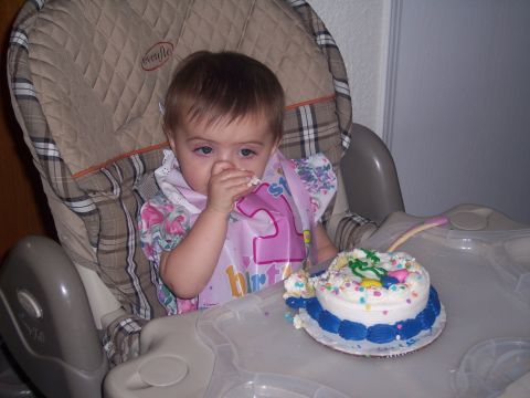 1972 Ford Ranchero - A baby sits in a high chair, wearing a bib and eating a birthday cake.