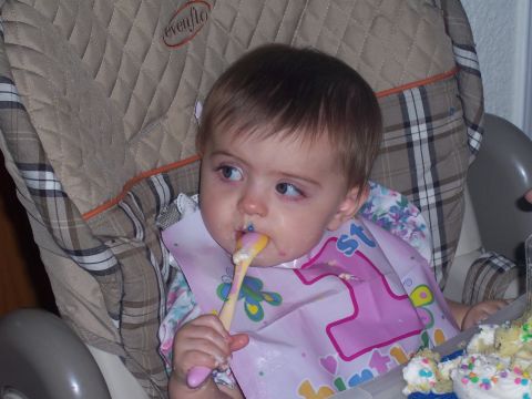 1972 Ford Ranchero - A baby sits in a high chair, happily eating with a spoon and wearing a bib that says '1st Birthday'.
