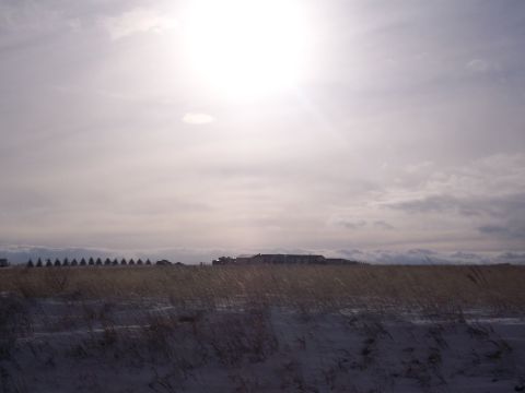 1972 Ford Ranchero - Several vehicles are visible in the distance across a field with dry grass and snow.