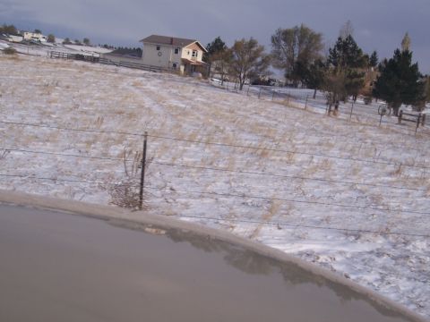 1972 Ford Ranchero - A house sits on a hill overlooking a snowy field with dry grass and trees.