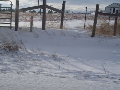 1972 Ford Ranchero - A winter scene shows a fence line and gate in a snow-covered field under a cloudy sky.