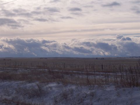 1972 Ford Ranchero - A wide expanse of a snowy field stretches under a dramatic sky filled with heavy clouds.