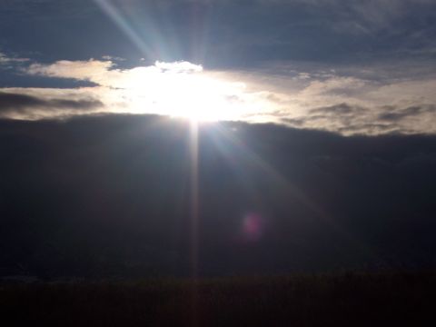 1972 Ford Ranchero - Sunlight streams through a break in the clouds, illuminating a dark, silhouetted landscape below.