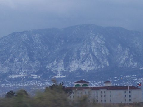 1972 Ford Ranchero - A wide view shows a snow-dusted mountain range behind a modern hotel building.