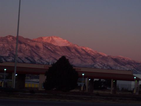 1972 Ford Ranchero - Snow-capped mountains glow in the warm light of sunset, with a car wash structure in the foreground.
