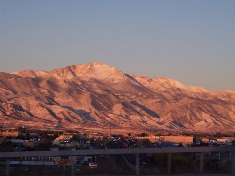 1972 Ford Ranchero - A scenic view of snow-covered mountains illuminated by the warm hues of a sunset, overlooking a distant city.