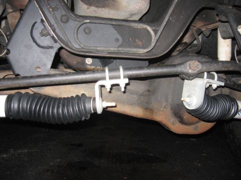 2001 Ford F-150 - Close-up view of the steering linkage and protective rubber bellows on a vehicle's undercarriage.