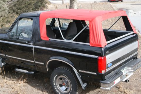 1994 Ford Bronco - This black Ford Bronco features a red soft top and a two-tone silver and black stripe on the rear panel.