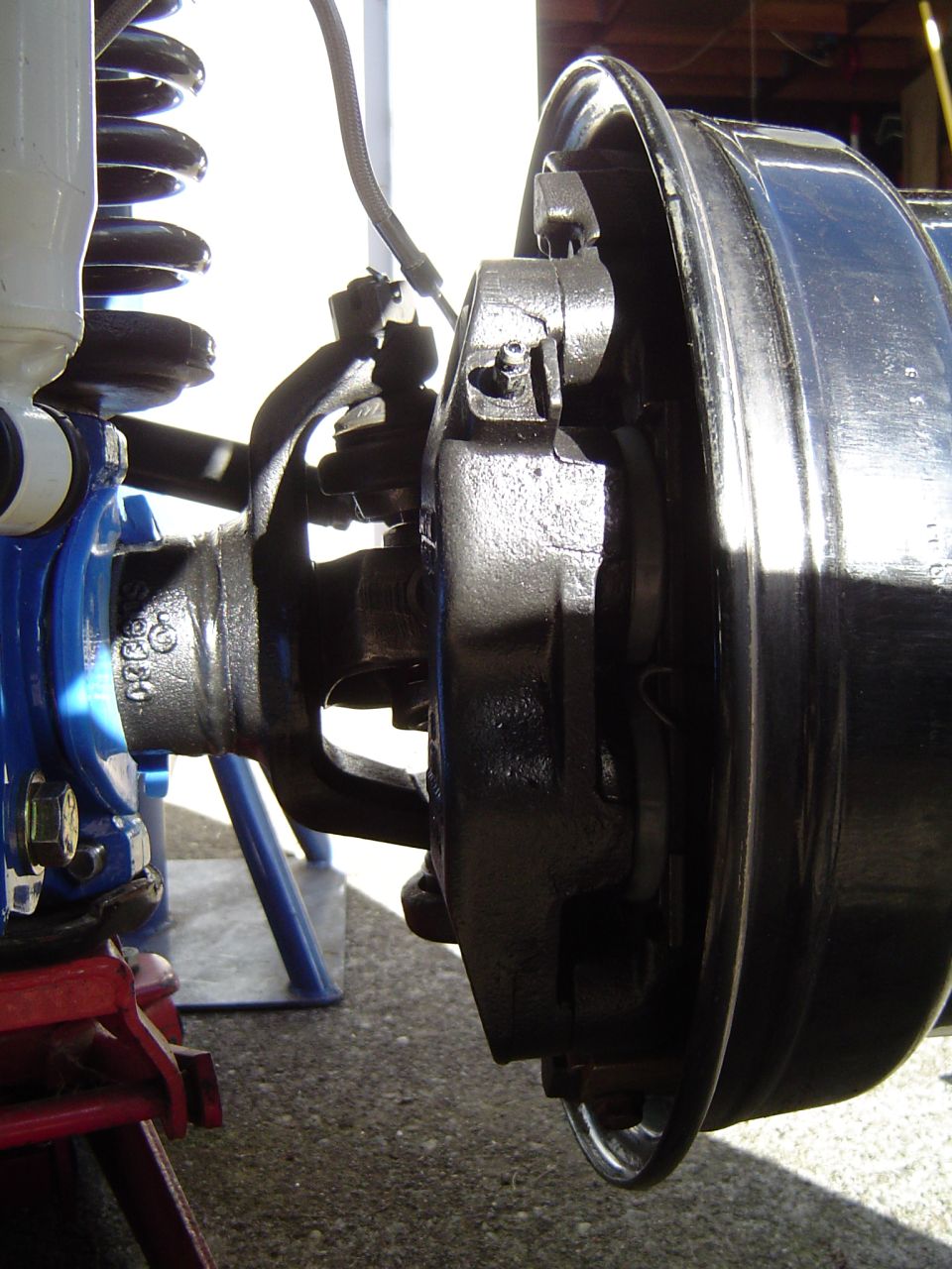 Front suspension and brake assembly with coil spring and brake drum