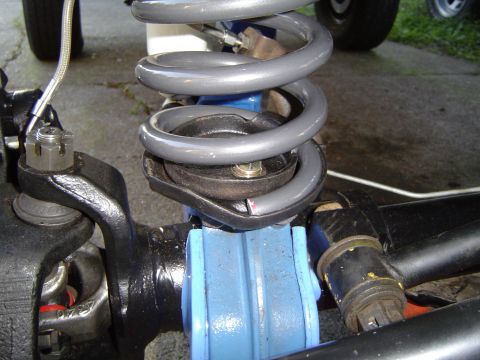 1978 Ford Bronco - This is a close-up view of a vehicle's front suspension system, focusing on the coil spring and shock absorber assembly.