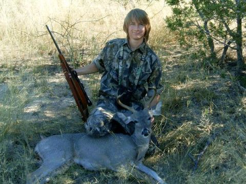 1983 Jeep CJ7 - Hunter with rifle and downed deer in a field. Watermark reads SUPERMOTORS.NET.