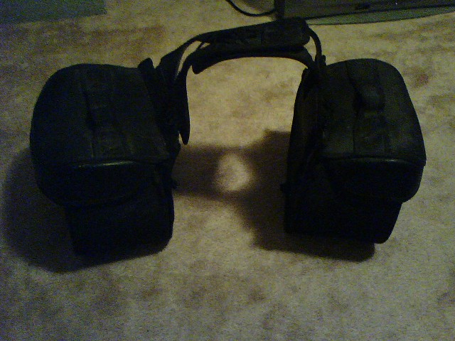 Pair of black leather motorcycle saddlebags with a connecting strap