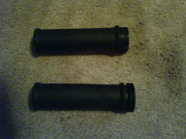 two black motorcycle grips on a carpeted surface