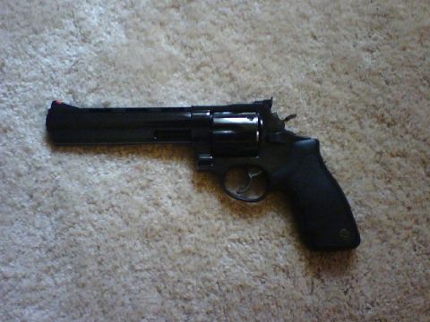 1995 Ford Bronco - A black revolver is shown from the side, resting on a textured carpet.