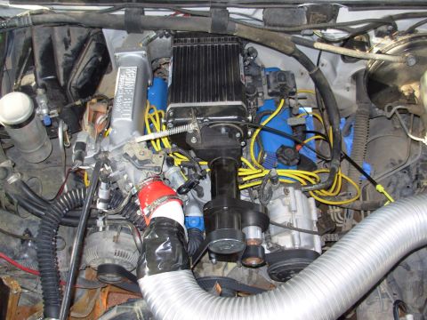 1994 Ford Bronco - Engine bay with custom intake and wiring; year and model not identifiable from image.
