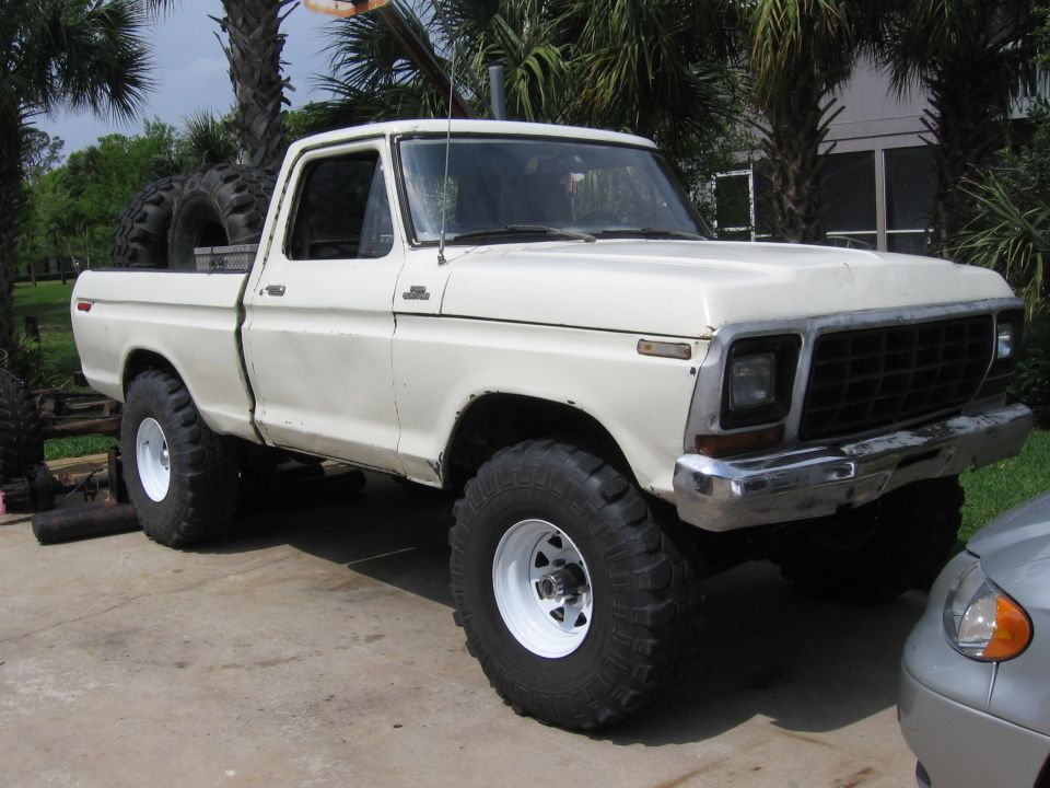 White 1979 Ford F-150 pickup truck with large tires, parked outdoors