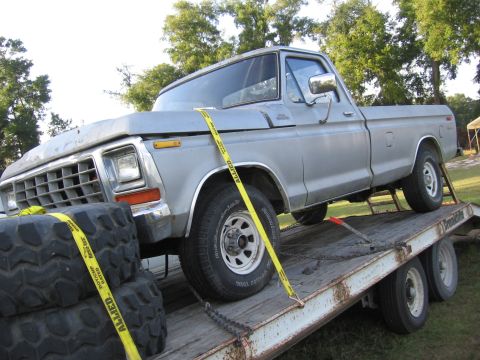 1979 Ford F-150 - A silver 1979 Ford F-150 pickup truck is loaded onto a flatbed trailer, ready for transport.