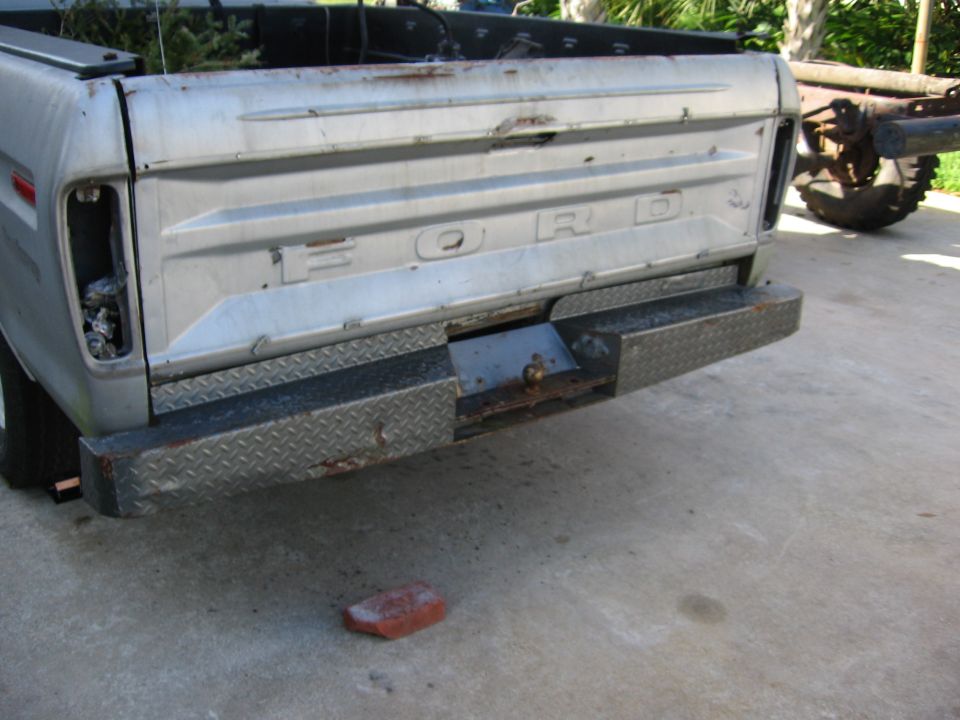 Rear of a 1973 Ford F-series pickup truck with a diamond plate bumper and a missing taillight