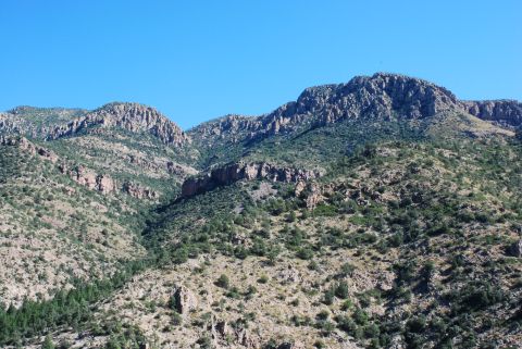1997 Ford F-250 - Mountainous terrain with sparse vegetation and a clear blue sky above. Supermotors.net watermark is visible.