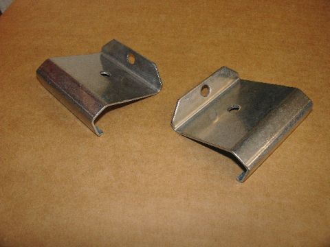 1993 Ford Mustang - A pair of metal brackets are shown against a textured brown background.