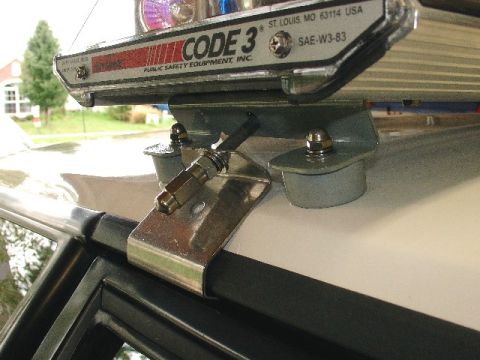1993 Ford Mustang - Close-up of a light bar mount attached to the roof of a white vehicle.