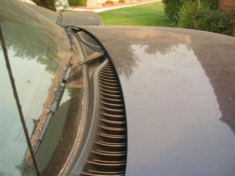 1975 Ford Ranchero - Close-up view of the windshield wiper and cowl area on a dusty vehicle, obscuring specific year or model details.