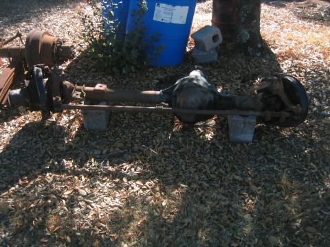 1973 Ford F-100 - A front axle assembly is shown outdoors, supported by cinder blocks.