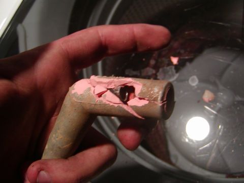 1991 Ford Bronco - A close-up shows a damaged spark plug wire boot being held by a hand.