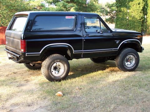 1983 Ford Bronco - This black 1983 Ford Bronco is shown from the side, a COMP sticker on the rear window.