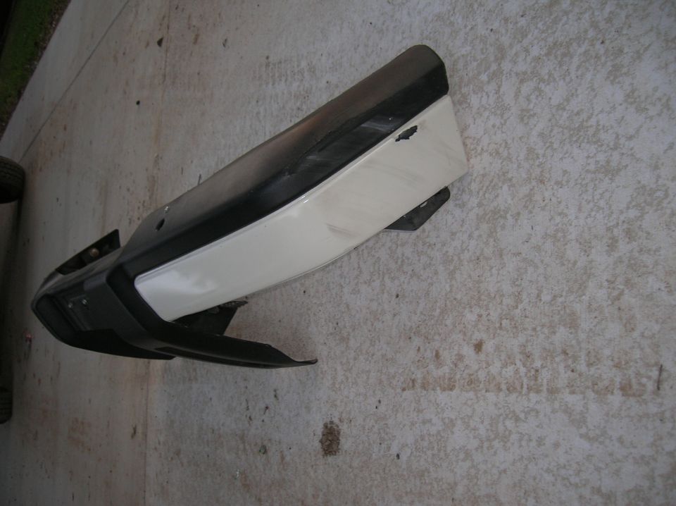 car bumper with black and white sections, lying on concrete