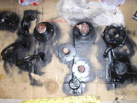 1996 Ford Bronco - Various automotive components are arranged on a cardboard surface, some appearing to be freshly painted.
