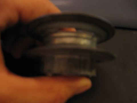 2001 Ford F-150 - Close-up of a metal pulley part being held by a hand.