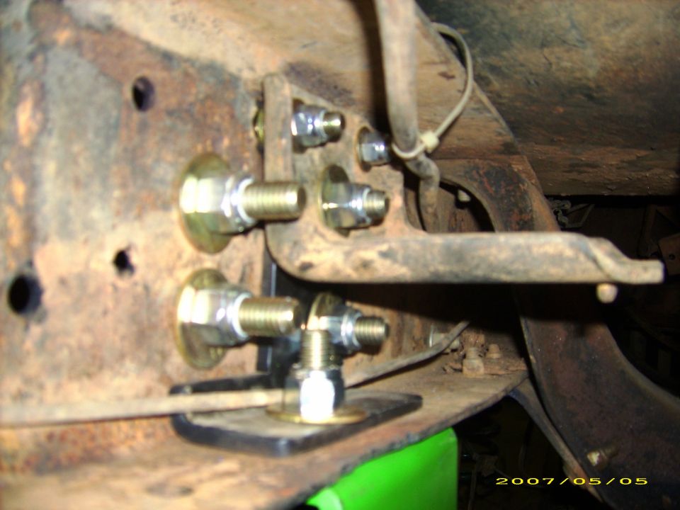 Close-up of bracket mounted to a rusty truck frame with bolts