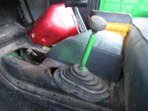1979 Ford F-150 - Interior view of a truck's cabin, showing a green gear shift lever and a red plastic container.