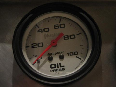 1900 Yugo Vega - Close-up of an Auto Meter oil pressure gauge with a red needle indicating low PSI.