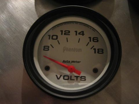 1900 Yugo Vega - This gauge measures voltage and is part of a vehicle's dashboard or custom setup.