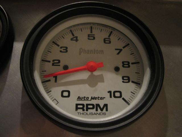 Close-up of an Auto Meter Phantom RPM tachometer with a red needle pointing to 1,000 RPM
