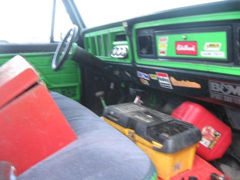 1979 Ford F-150 - The interior of a truck features a bright green dashboard adorned with various racing and sponsor stickers, including Elkoil and Marlboro.