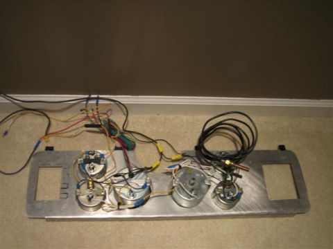 1900 Yugo Vega - A dashboard instrument cluster with multiple gauges and associated wiring is shown, detached from a vehicle.