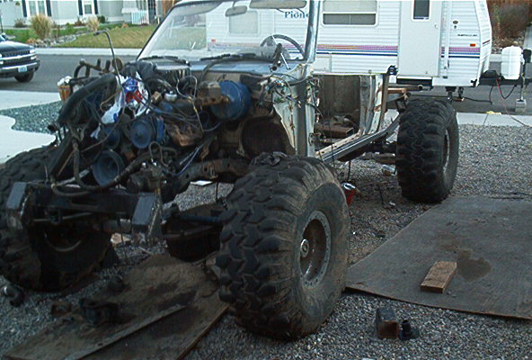 Off-road vehicle with large tires and exposed engine, undergoing construction