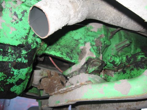 1979 Ford F-150 - Close-up view of the engine and exhaust system, showing green painted components and a white exhaust pipe.